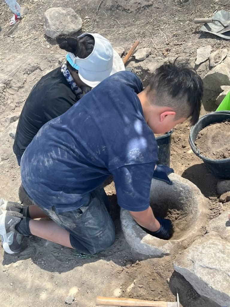 Yohan cleaning out a mortar.