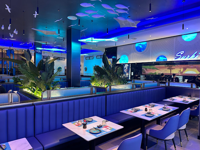 Interior de Sushi Nami con sofás azules y decoración marina