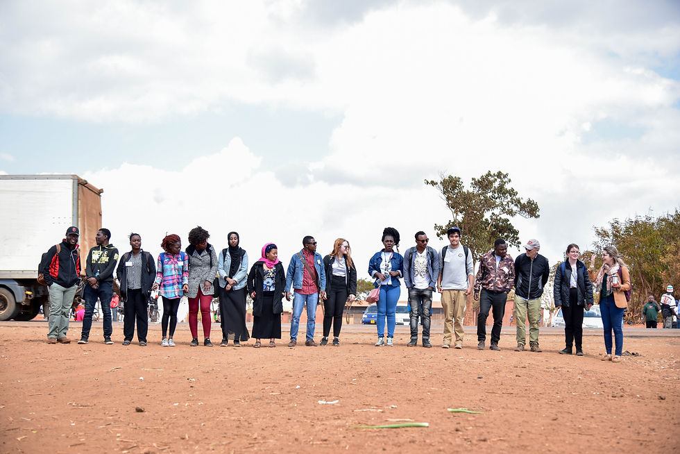 Group photo of international seminar participants on refugee issues in Malawi, July 2019 — a diverse cohort of Canadian, Malawian, and refugee students from Dzaleka Refugee Camp, alongside professors Glen Peterson (University of British Columbia) and Peter Mvula (University of Malawi), coordinators Virginie Tardif and Lizzie Dube. The seminar focused on youth leadership for refugee self-reliance and culminated in a report for the Government of Malawi and UNHCR.