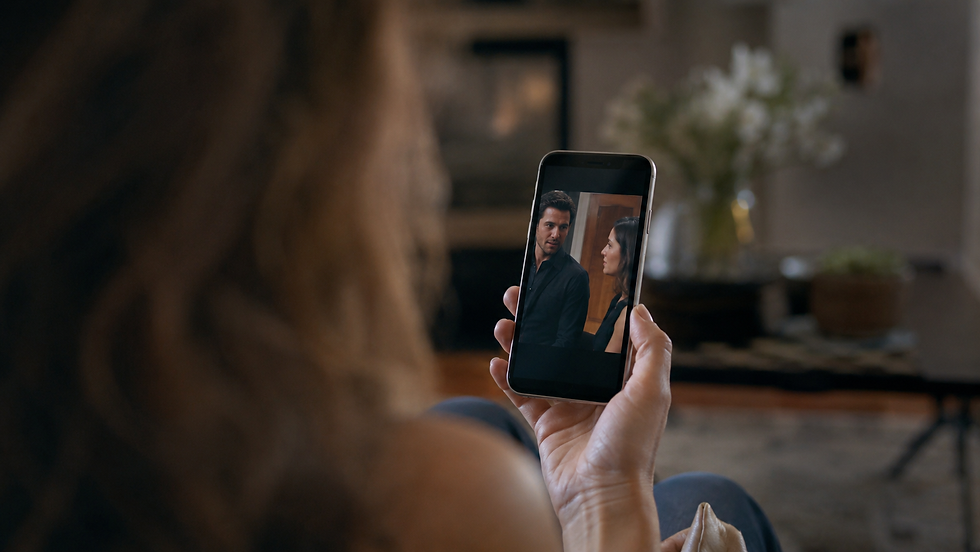 Low-angle view of a phone held in one hand while a vertical drama scene plays on the screen.