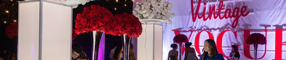Elegant event setup by Stellar Event Designer in South Georgia, with a buffet, flowers, and "Vintage VOGUE" banner.