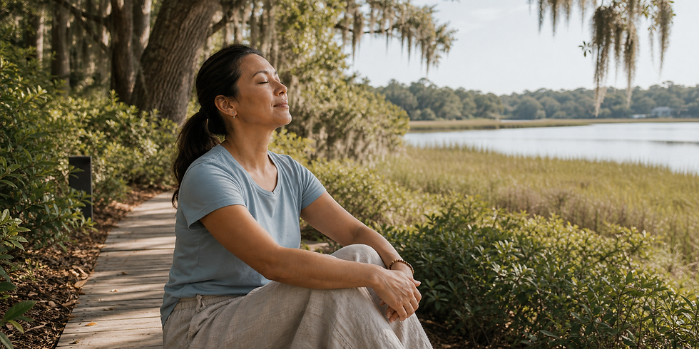 Adult sitting quietly beside a shaded outdoor path and water view, practicing mindfulness for stress relief.