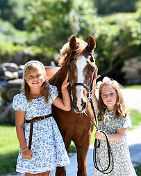 two cute young students holding our pony Westchester