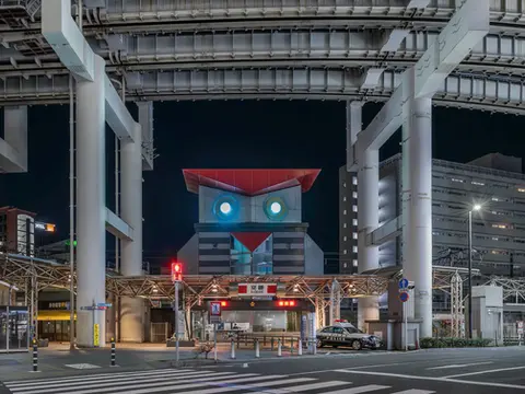 Night view of owl-shaped Koban police box in Chiba, Japan with urban highway structure