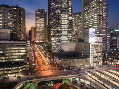 Night view of Cocoon Tower in Shinjuku with light trails and city buildings