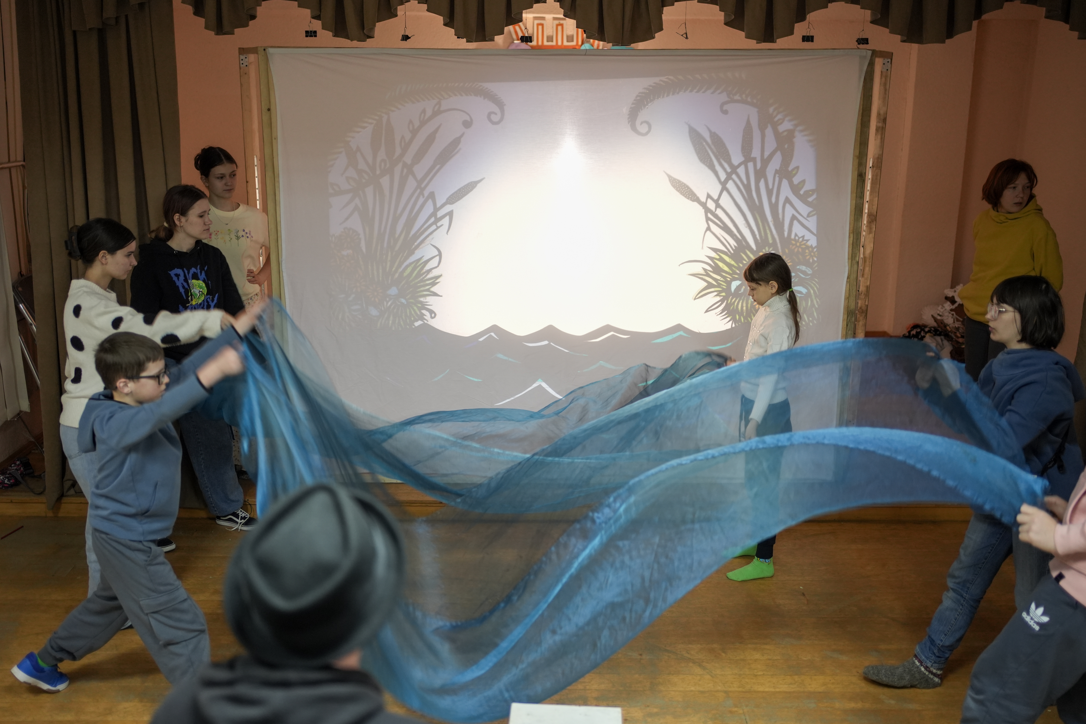 Children are operating shadow puppets on the screen in Transcarpathia, Ukraine. 2025