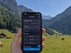 Smartphone mit aktiver Nomad eSIM und LTE-Verbindung vor Schweizer Berglandschaft