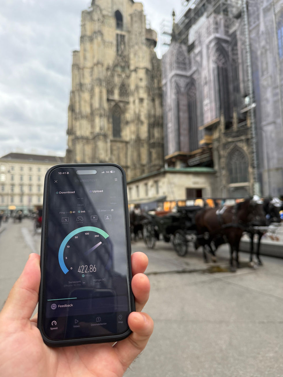 Smartphone mit laufendem Speedtest vor dem Stephansdom in Wien.