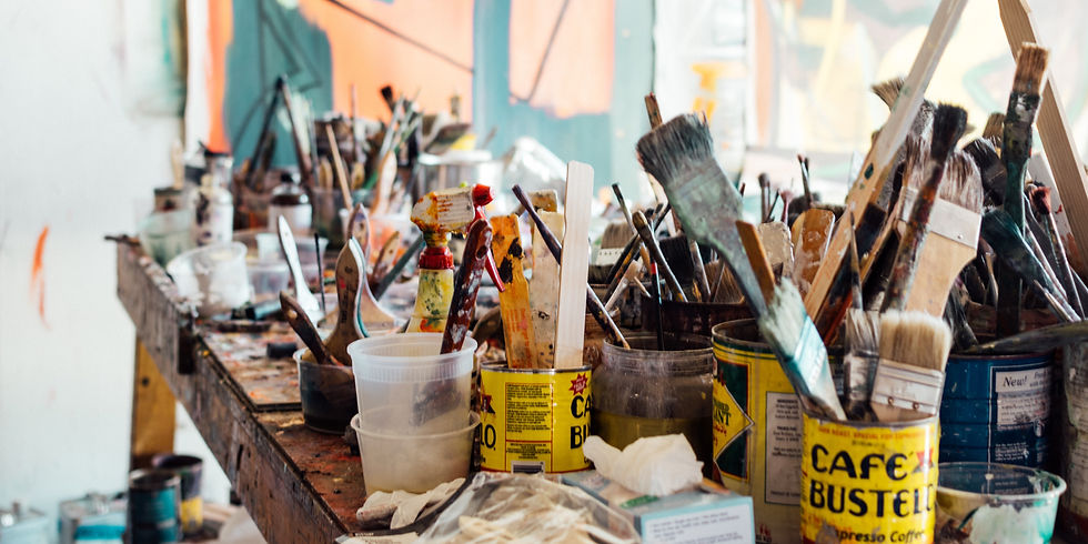 a table full of art supplies and paint brushes