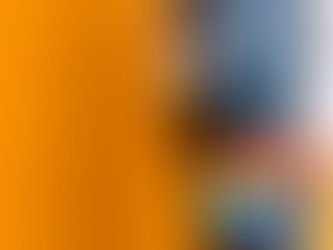 A person holding a fidget with an orange background