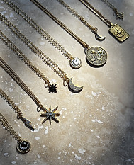 Flatlay of celestial necklaces on granite tile