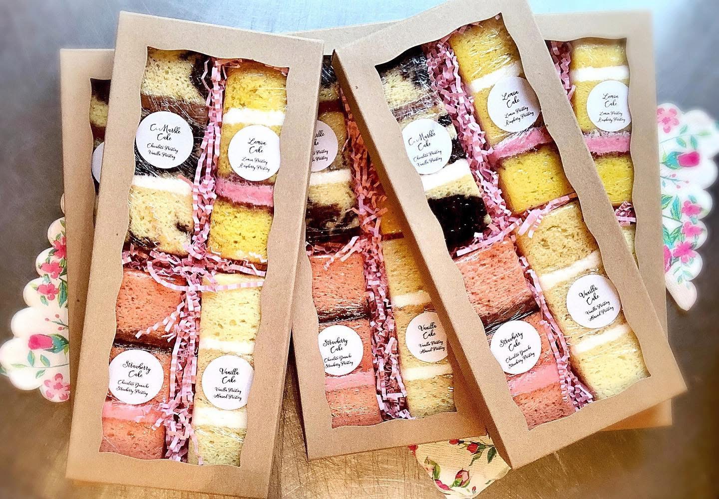 Real Sprinkle Me Silly cake flavor samples arranged in kraft window boxes, each showcasing different cake layers and fillings