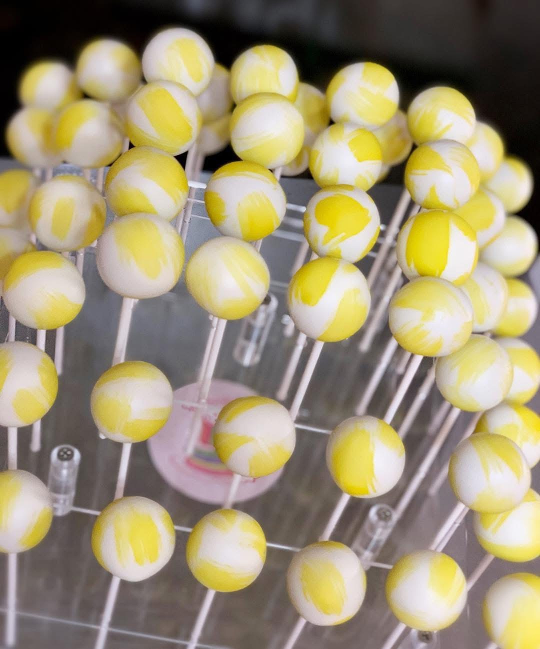 Yellow and white swirled custom cake pops on sticks — Sprinkle Me Silly original photo