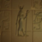 Symbole en or représentant la déesse égyptienne Isis sur un mur de hiéroglyphes..jpg