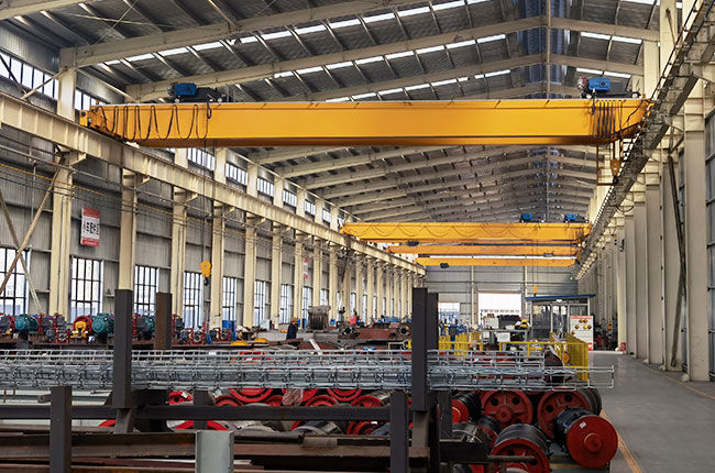 Overhead crane berjalan di gudang menggunakan balok atas untuk mengangkat beban berat