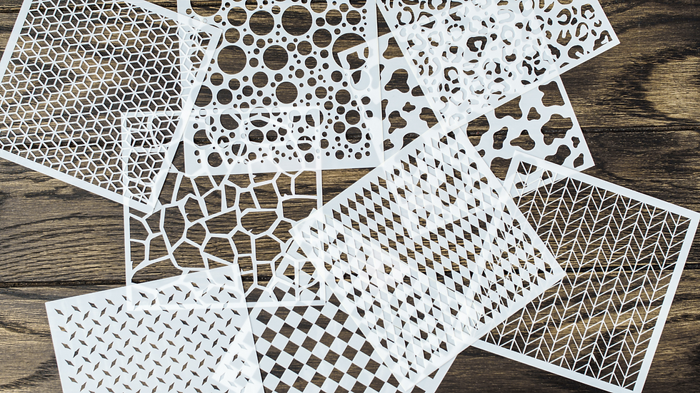 White paper stencils with geometric patterns are scattered on a wooden surface. Patterns include circles, hexagons, and diamonds.
