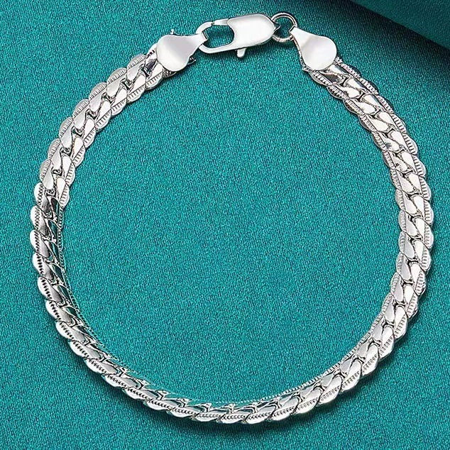 Thumbnail: Sterling silver flat curb chain bracelet styled alongside a watch for a modern look