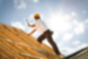 Construction worker building roof on sunny day