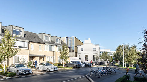A CGI image of a new build hostel development, yellow brick facade and cladding window details - the development is set in the background behind a row of yellow brck houses