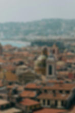 Panoramic Nice cityscape: terracotta rooftops, church domes, and coastal view