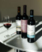 Three bottles of red wine and a glass