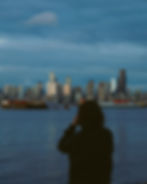 Person photographs Seattle skyline from waterfront