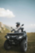 Person in helmet riding ATV in mountains