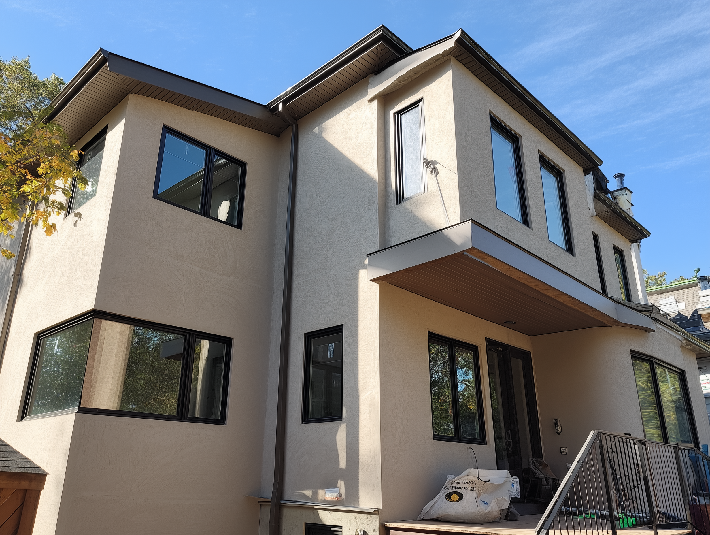 Modern house exterior with stucco siding, black windows completed by Monarch Masonry, Located in Toronto