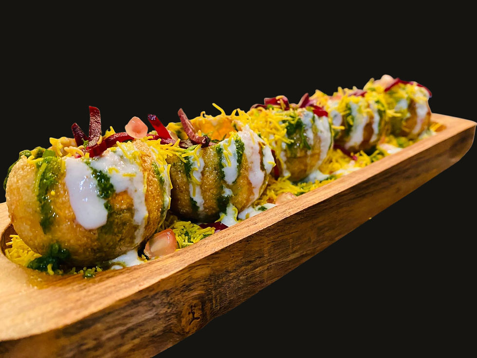 Wide-angle view of assorted Indian chaat bowls on a wooden table.