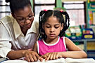 Daycare teacher with preschool child in childcare setting