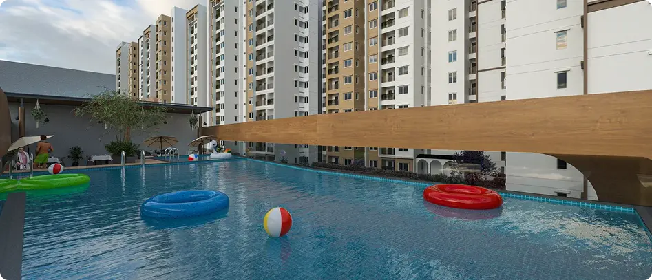 Swimming pool with residential towers behind at Sowparnika Rhythm of Rain Whitefield