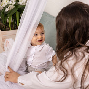 fotografia infantil de mãe e filho brincando em cenário leve e minimalista infantil