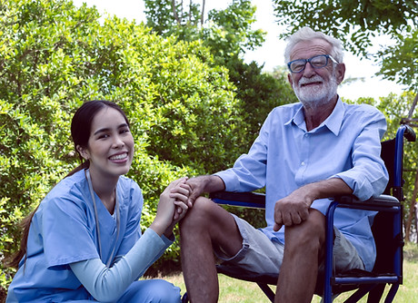 Happy care taker with wheelchair senior man in garden, Old disabled man sitting on wheelch