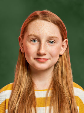 School portrait of a young girl with auburn hair on a deep green Evergreen background — family personalization option