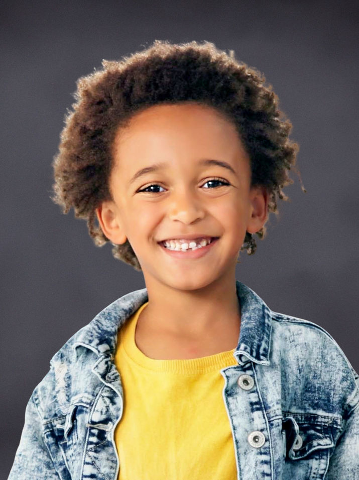 Student portrait with a dark gray textured studio background.