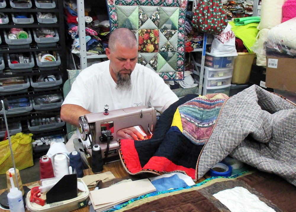 Inmate sewing quilt as part of restorative justice