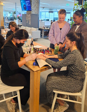 Guests receiving manicures around a shared table at a group pampering event.