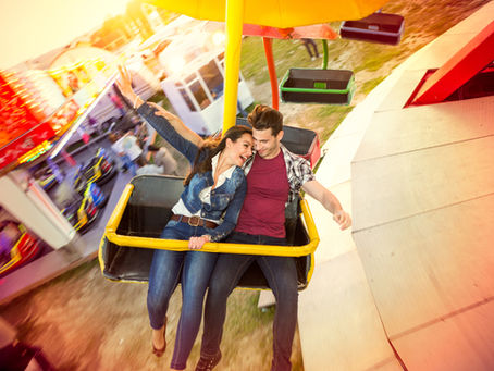 Couple laughing together on a Ferris wheel, sharing a lighthearted moment