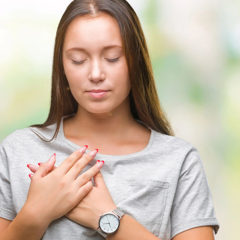 Woman with hand mindfully on her heart, suggesting healing