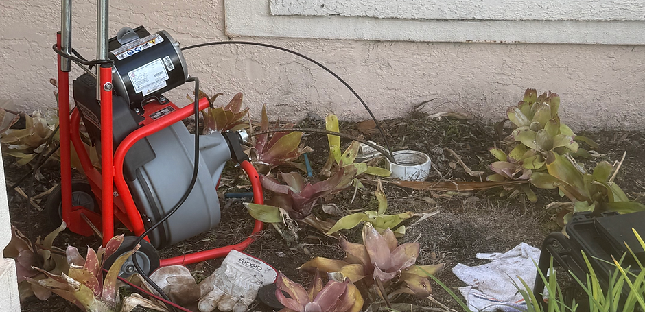 Drain snake machine in from of home near window and cleanout