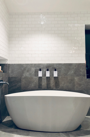 Unik plattsättning i badrum med badkar.