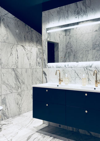 Stort badrum med vägghängd toalett och kommod