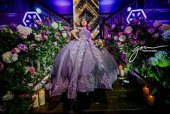 Enchanted garden quinceanera decorations with flowers, greenery, butterflies and warm twinkle lights