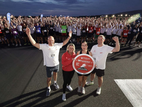 4 people at a marathon in front of a crowd cheering