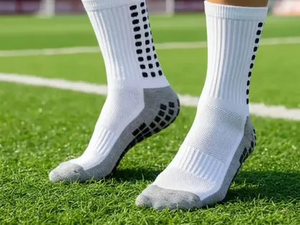 witte gripsokken op kunstgras gedragen door een voetballer