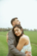 Cinematic shot of couple hugging in a field 