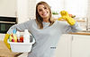 Femme de ménage Indépendante souriante avec produits de ménage