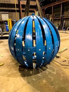 Completed blue-painted globe replica on the shop floor, awaiting installation on the Manhattan Bridge