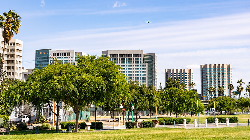 San Jose's downtown skyline as seen from the shoreline of Guadalupe River Park on a sunny