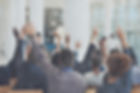 Shot of a group of businesspeople raising their hands to ask questions during a conference